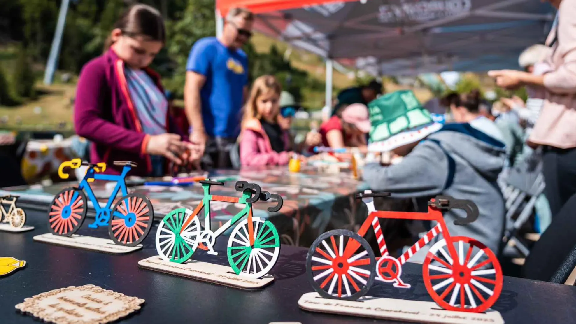 Ateliers de vélos et leurs socles. C'est une animation sans inscription accessible aux enfants à partir de 3 ans et leurs familles. Ils décorent et assemblent leurs création. Ils repartent avec un vélo et un maillot gravés avec le nom de l'événement ou de la station de ski. Cette animation est à destination du Tour de France et stations de Savoie (Courchevel, Tignes, Val d'Isère, Sainte Foy, La Rosière, Les Arcs, Peisey-Vallandry, La Plagne, Val Thorens) et Haute Savoie (Megève, Combloux, Chamonix, Morzine les Gets, Annecy, Avoriaz, La Cluzaz...). Ce sont des créations locales et durables fabriquées en Savoie